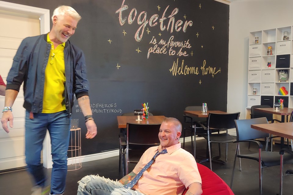 OUTLoud's Seth Compton tests out a new beanbag chair donated by Giant Tiger while designer Steven Sabados looks on.