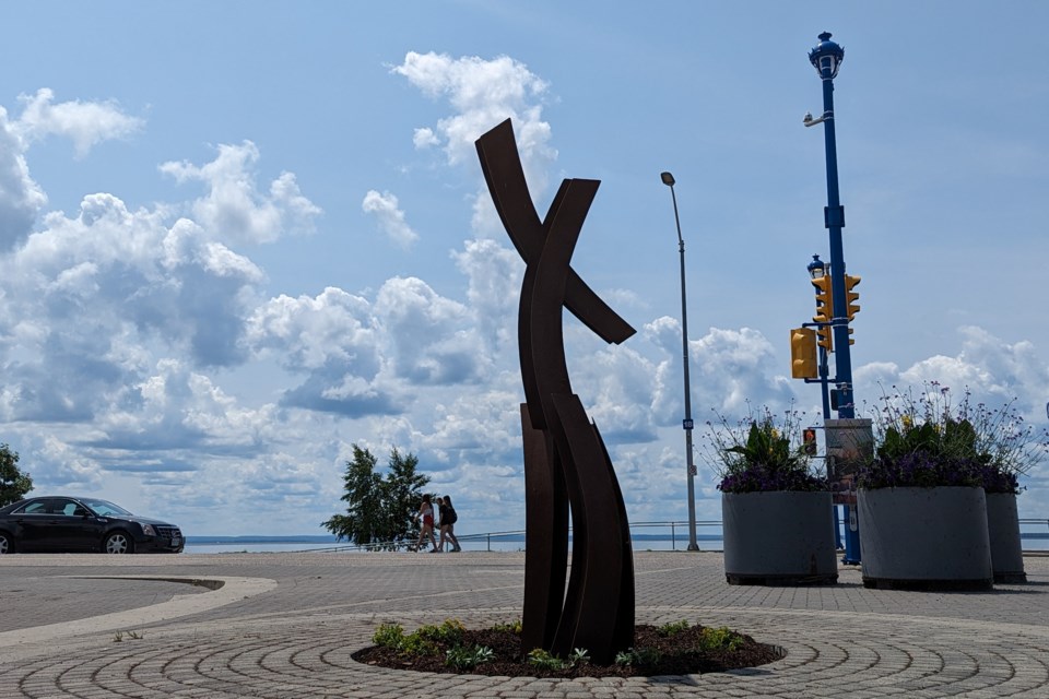 The public art piece is located at the top of the steps on the waterfront side of the pedestrian underpass.