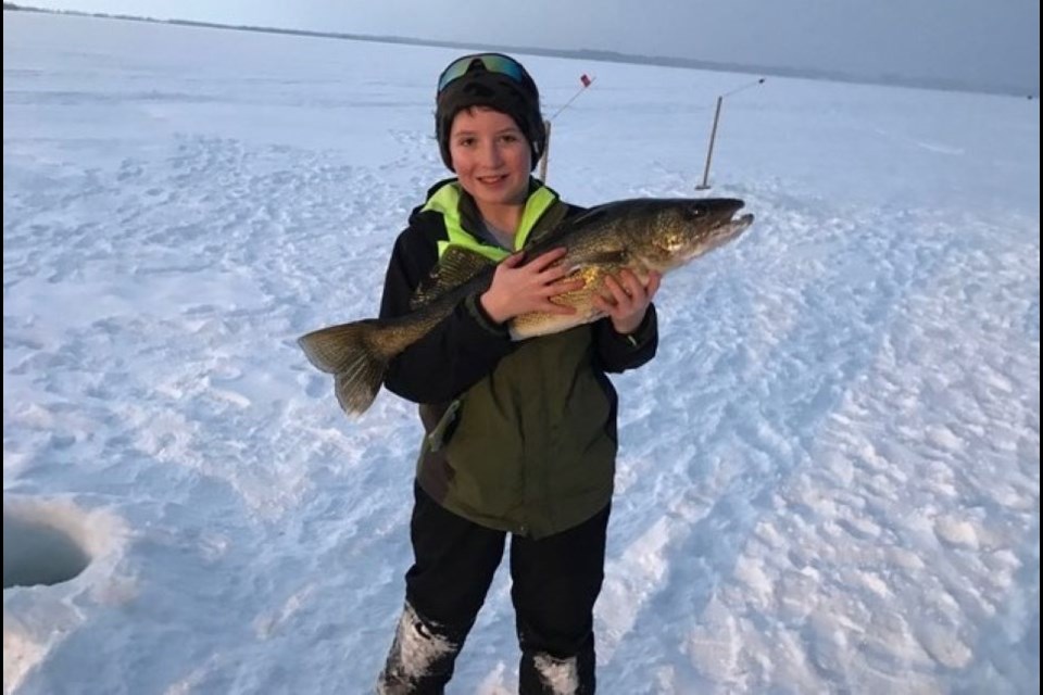 Jacob Hines proudly displays his Lake Nipissing walleye caught while ice fishing.