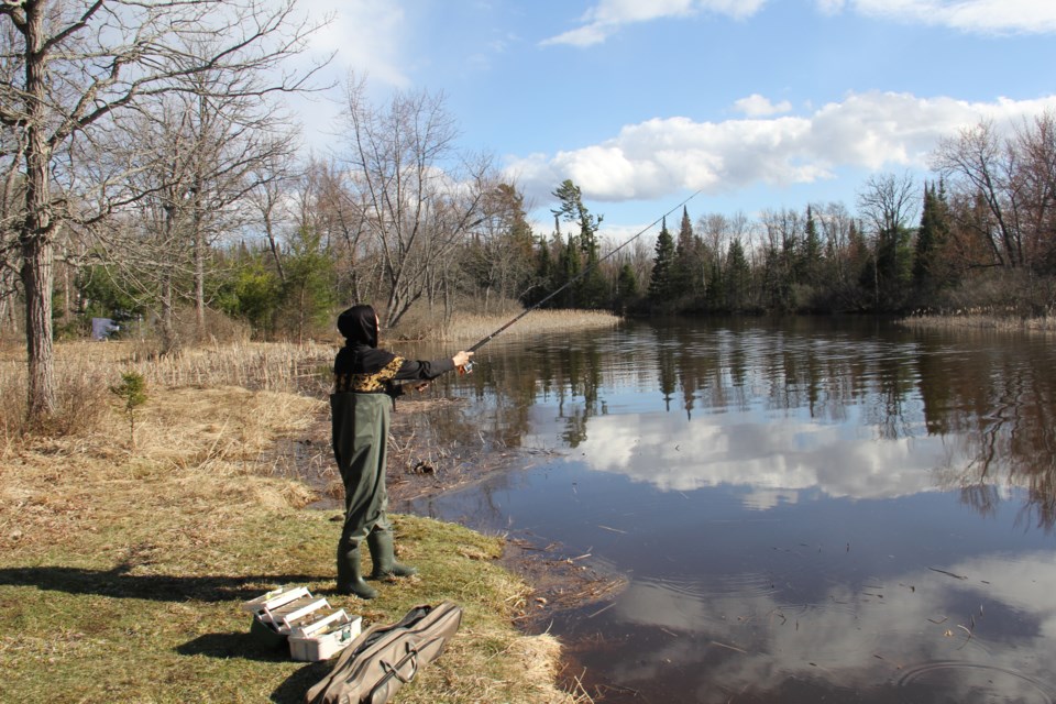 Dylan Reid of Powassan tosses a line into the rising waters of the Lavase River. Water has reached the top of the banks, and in some cases is over the top.