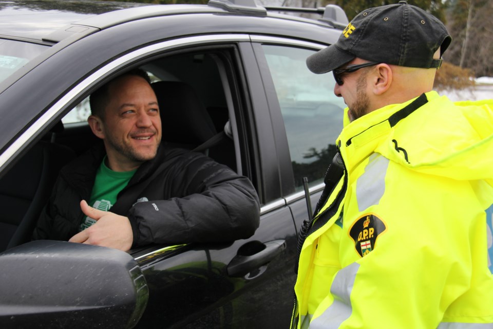 Const. Stephane Bellmare of the Snowmobile, ATV and Vessel Enforcement (SAVE) team chats with Callander resident Patrick McCourt during Friday's Festive RIDE kickoff. Photo by Jeff Turl.