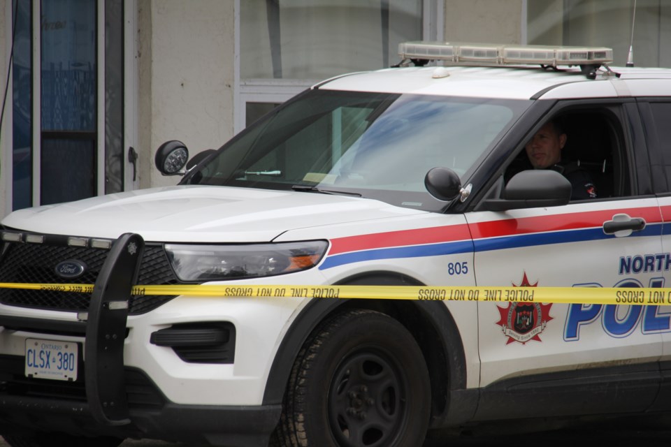 A North Bay police officer guards a taped-off area around a room at the Dolphin Motel on Lakeshore Drive.