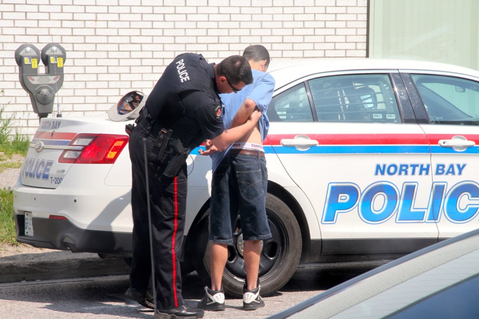 Constable Stacy Jackson arrests a suspect on Fisher Street.  Photo by Chris Dawson.  