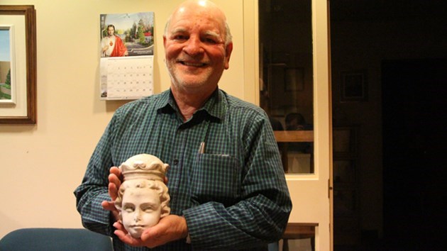Father Gérald Lajeunesse holds the original head from a baby Jesus statue that had been stolen from Ste. Anne des Pins church nearly a year ago. Photo: Matt Durnan.