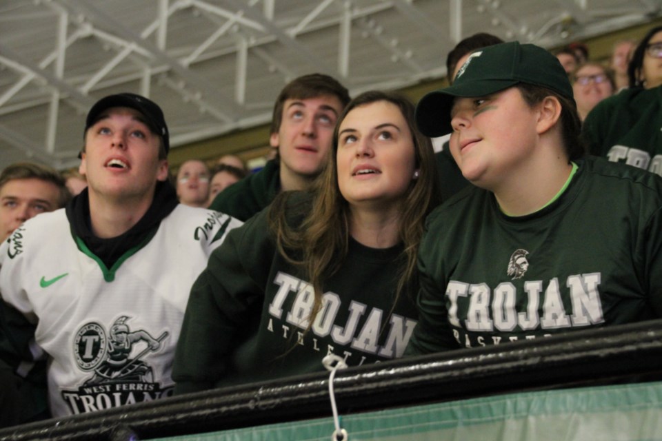 Trojans watch the big screen at the Gardens as they do their spirit dance.  Photo by Chris Dawson.  