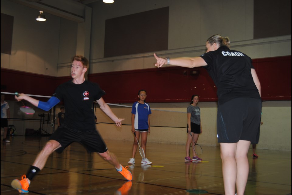 Olympian Valerie Loker directs Gabriel Pharand during a drill at the High Performance Badminton Camp