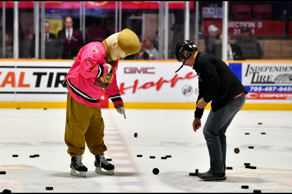 Sarge helping to clean up after the Chuck-a-puck intermission event. Photo by Tom Martineau/BayToday.ca 