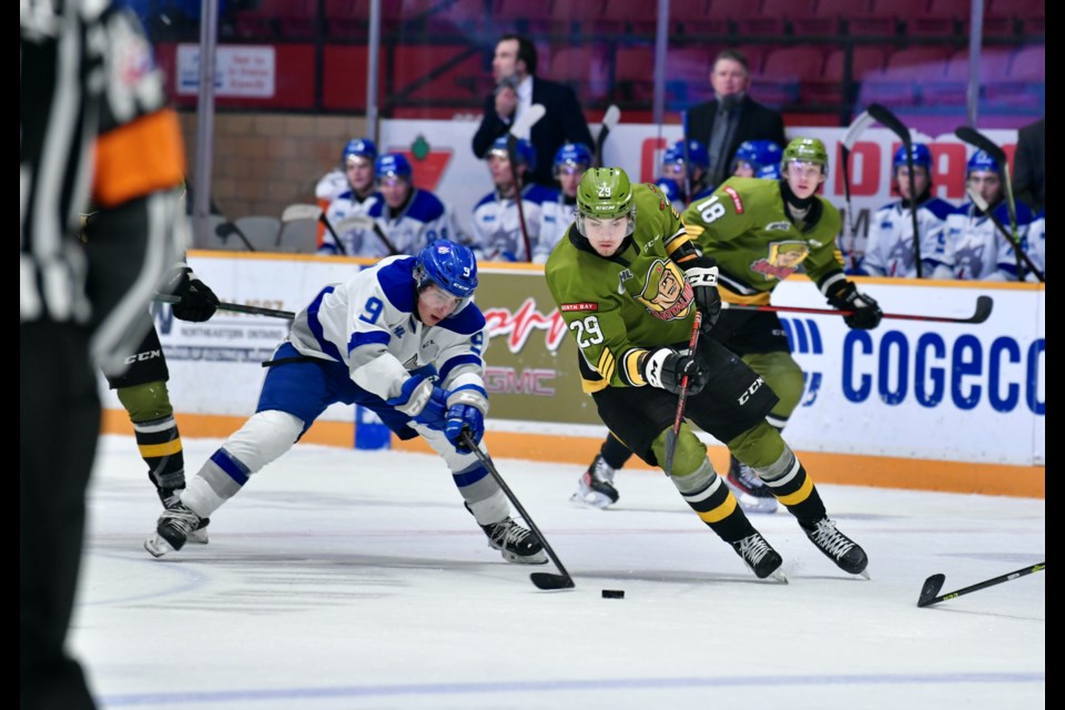 Sima battles for the puck in the neutral zone against Assadourian of the Wolves. Photo by Tom Martineau/BayToday