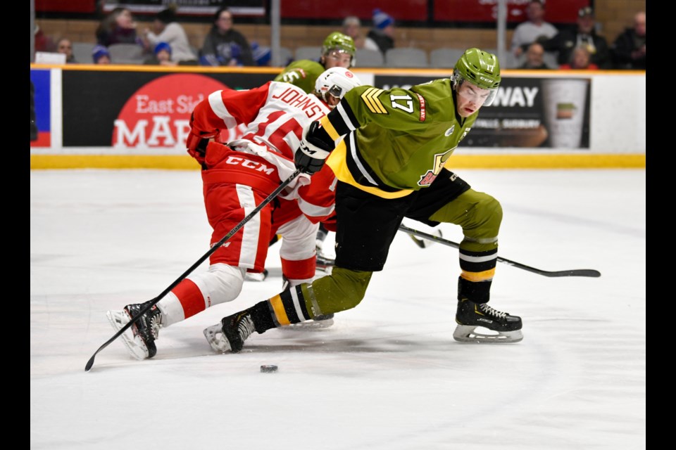 Brazeau tries to fight off a Hounds checker. Photo by Tom Martineau/BayToday.ca. 