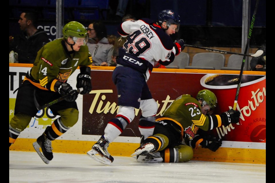 Cole Coskey of the Saginaw Spirit hammers Daniil Verity of the Battalion into the boards during OHL action Sunday at Memorial Gardens. Coskey was called for boarding on the play. Photo by Tom Martineau.
