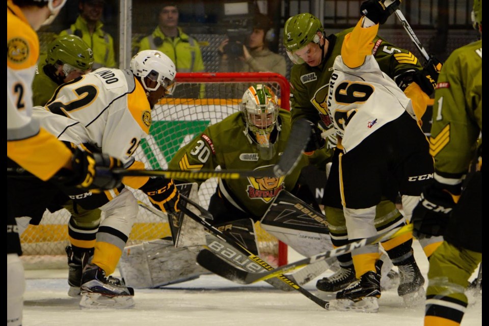 Battalion goalie Brent Moran and defenceman Jesse Saban fight to find the puck in OHL action Thursday at Memorial Gardens. The Troops defeated the Sarnia Sting 7-4. Photo by Tom Martineau.