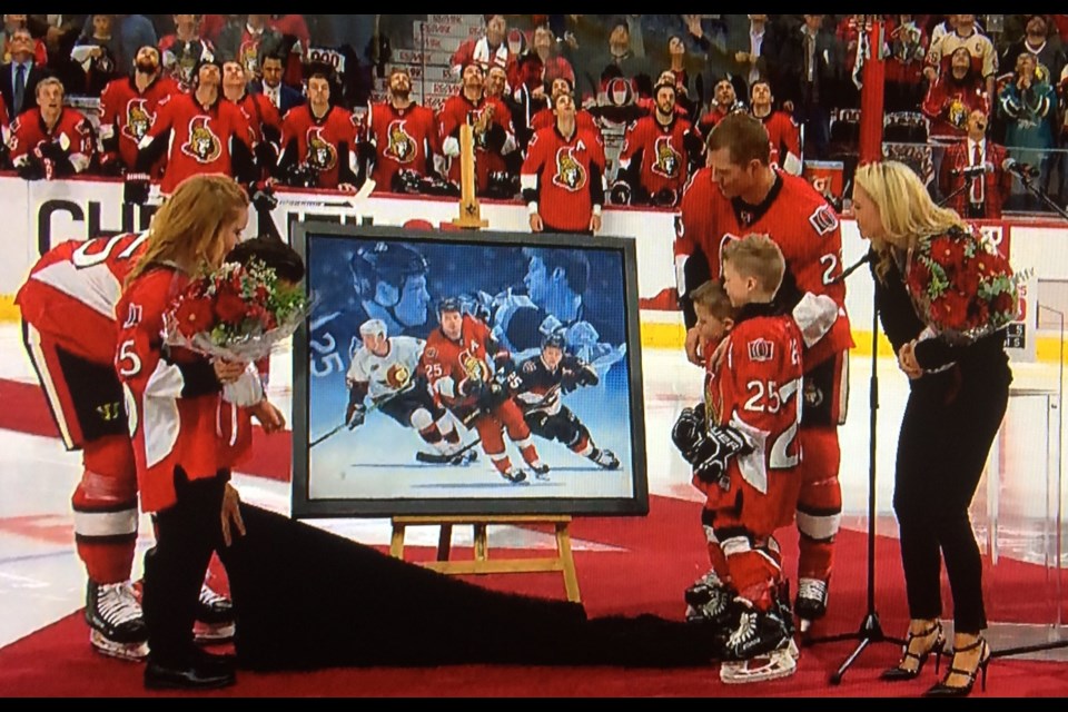 Chris Neil was presented with a painting, silver puck and stick at the ceremony.