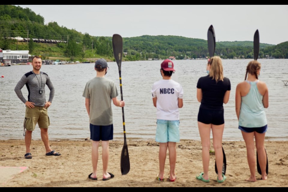 North Bay Canoe Club Head Coach Mihail Oghina (Left) talks to his athletes at Olmstead Beach. Photo provide by Konstantin Avramets.