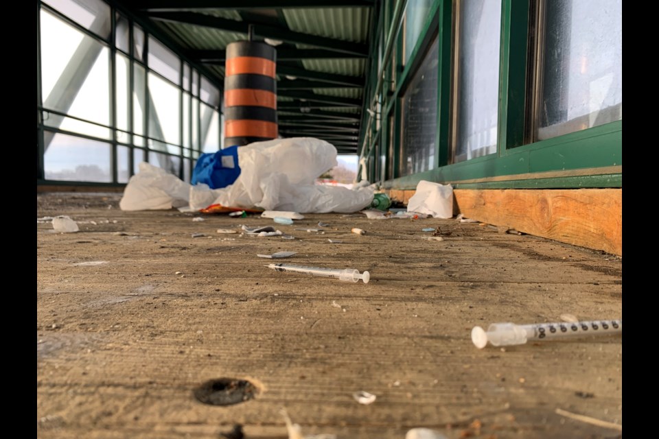 Needles and garbage near the damaged floor on the HIghway 11/17 walking bridge.  Photo by Chris Dawson/BayToday. 