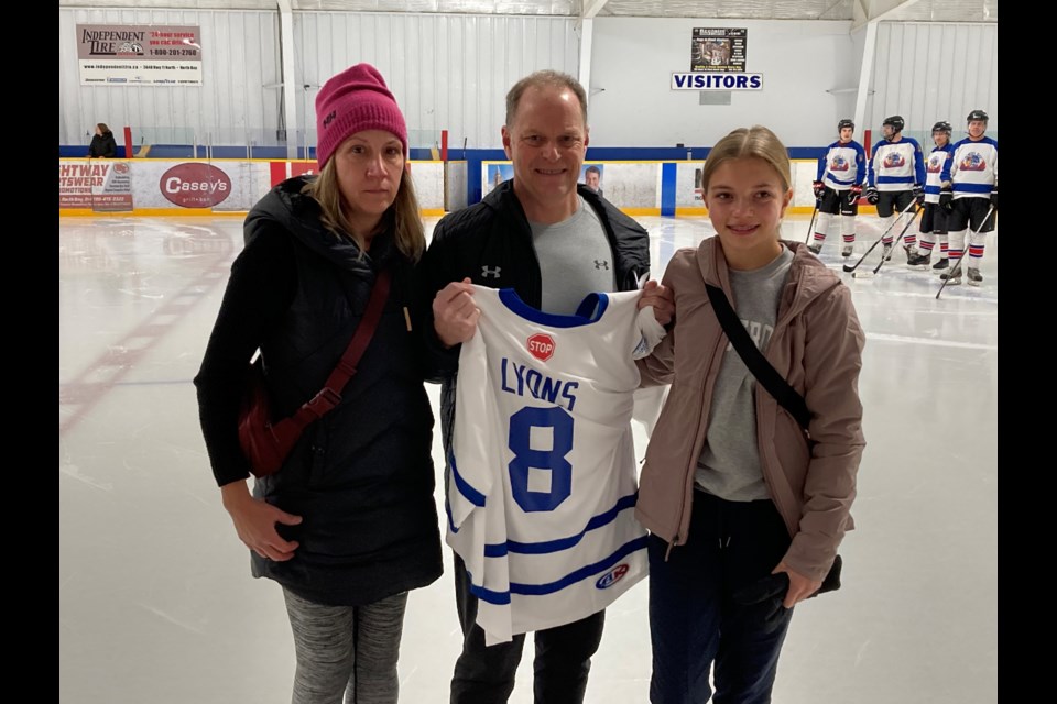 (l-r) Lesley, Mark, and Hannah Lyons with keepsake jersey at a ceremony to retire son/brother   Jack Lyon's number 