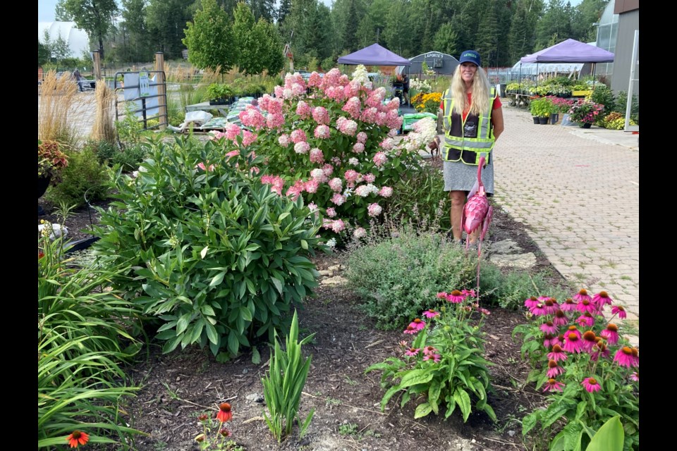 Lori Laporte stands beside her tribute garden honouring deceased family members and staff who 