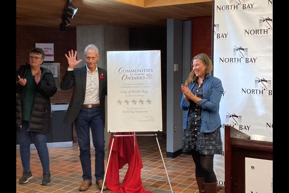 North Bay Mayor Peter Chirico holds up a high five after unveiling the city being awarded a perfect five-bloom rating.