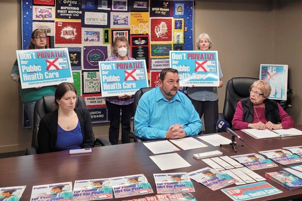 (Front from left) Jen McCarthy, Henri Giroux, and Karina Tulisalo present the North Bay Health Coalition’s concerns about Bill 60. Standing in solidarity behind them from the left is Louise Walker, a retired nurse, Sue McIntyre a working nurse, and concerned citizen Betty Hotchkin.