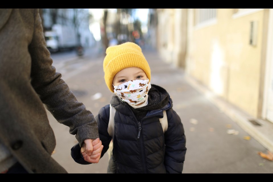 A child wears a face mask to protect against COVID-19