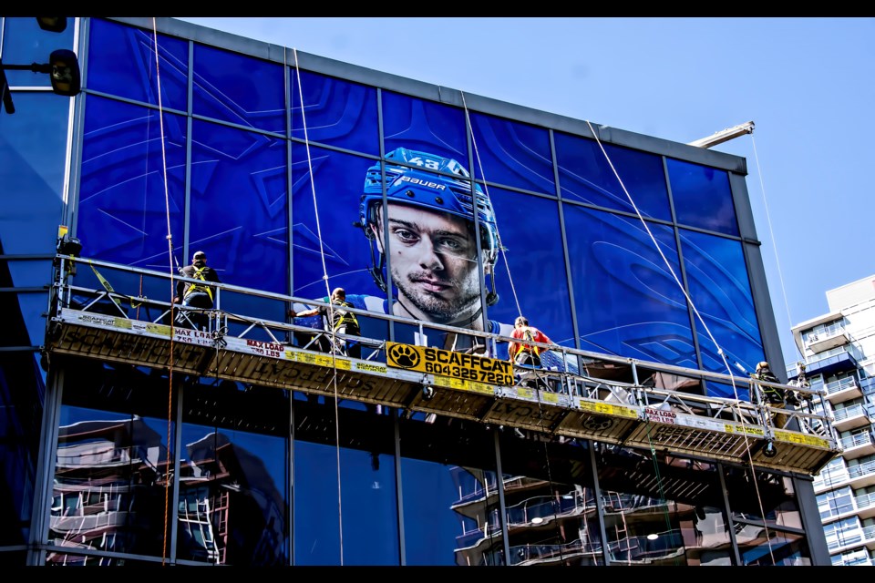 Workers are putting on new decals over the windows of the main entrance at Rogers Arena. | Chung Chow, BIV 
