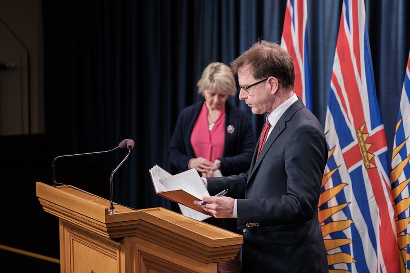 Adrian Dix with Bonnie Henry at podium
