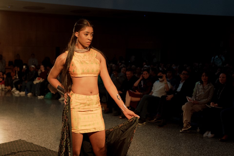 A model wearing clothing by designer Minaxi Mahedia walks down the runway at BKLYN Fashion Academy's 2023 runway show at the Brooklyn Public Library.