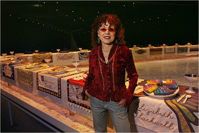 The triangular shaped sculpture, conceptualized and designed by Judy Chicago, was created by hundreds of women volunteers in ceramic sculpture and woven, hand embroidered and sewn fabrics, all traditional 