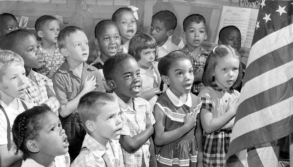 (A year after the Supreme Court?s Brown vs. Board of Education ruling ended school segregation, first-graders recite the Pledge of Allegiance in 1955 at Gwynns Falls Elementary School.) [Source:Richard Stacks, Baltimore Sun]