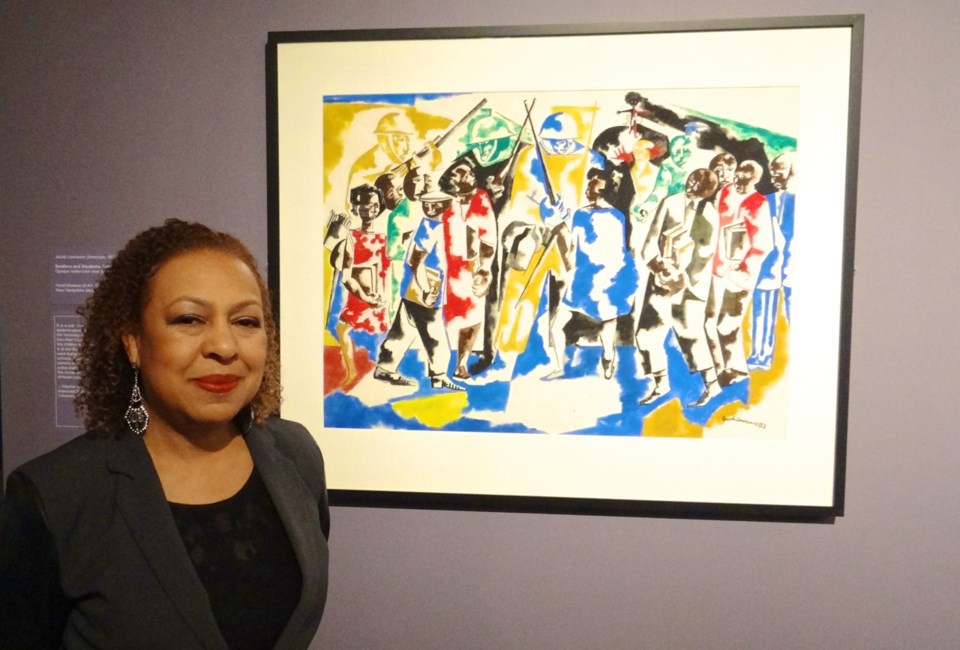 ?Witness: Art and Civil Rights in the Sixties,? at the Brooklyn Museum. Kellie Jones, the exhibit&#039;s co-curator, stands next to Jacob Lawrence, Soldiers and Students,