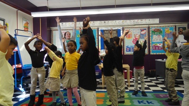 Children stretch after story time at TFOA Professional Preparatory Charter School