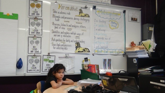 A student sits quietly in a classroom at TFOA Professional Preparatory Charter School