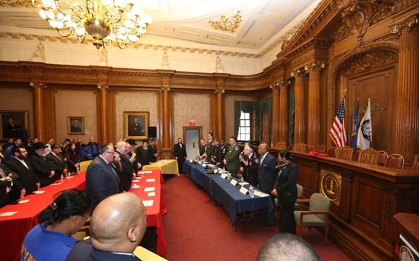 Brooklyn Borough President Eric Adams and Deputy Borough President Diana Reyna stand with Jewish community leaders and representatives of City agencies as Rabbi Dr. Alvin Kass, chief chaplain of the New York City Police Department, delivers the invocation at a pre-Passover community open dialogue in the courtroom of Borough Hall.   Photo: Yossi Goldberger