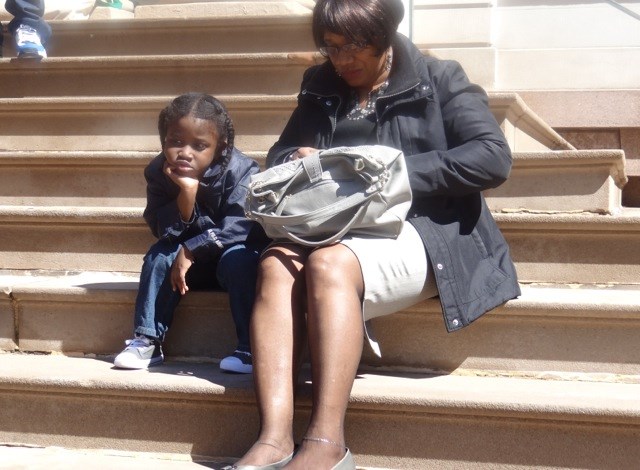Symeir Talley-Jasper waits on the steps of City Hall with his grandmother during the press conference for the Audible Alarms Bill