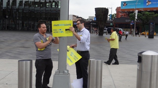 Campaigners outside the subway station at Barclays Center, putting up posters to inform residents about the Paid Sick Leave Law