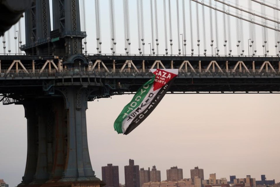 Cops are investigating the source of a giant flag in support of Palestine that was hung from the Manhattan Bridge