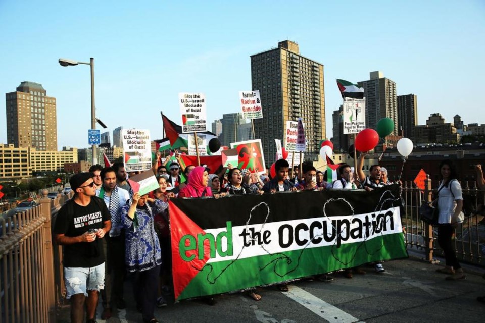 Cops are investigating the source of a giant flag in support of Palestine that was hung from the Manhattan Bridge
