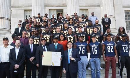Brooklyn Borough President Eric L. Adams, sporting a new Brooklyn Bolts cap, presents a citation to the Bolts of the Fall Experimental Football League (FXFL), the borough¹s first professional football team since 1949, at a rally on the steps of Brooklyn Borough Hall; in addition to the members of the Bolts in the background, he is joined by (from left to right) Bolts Head Coach John Bock, FXFL Commissioner Brian Woods, New York Mets Chief Operating Officer Jeff Wilpon, Brooklyn Chamber of Commerce President and CEO Carlo A. Scissura, Special Counsel to the Brooklyn Borough President Ama Dwimoh, Council Member Mark Treyger and members of the Brooklyn Technical High School Engineers. Photo: Kathryn Kirk/BP¹s Office