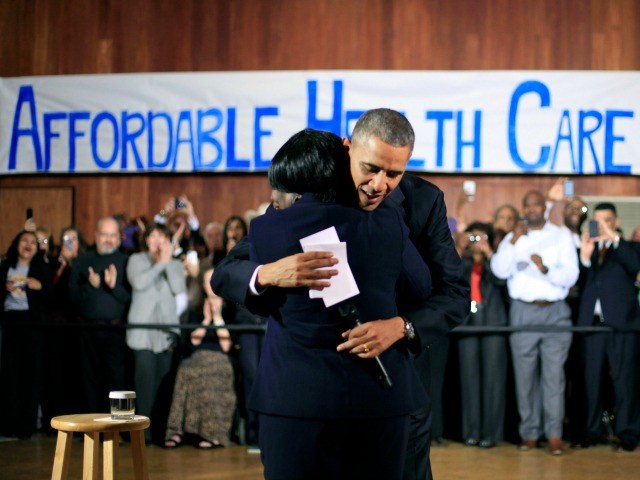 President Barack Obama hugs Edna Pemberton, who introduced him, before speaking with volunteers who helped people enroll through the HealthCare.gov site at Temple Emanu-El Wednesday, Nov. 6, 2013, in Dallas. Obama traveled to Texas to pitch health care and raise money for the Democratic party. 
