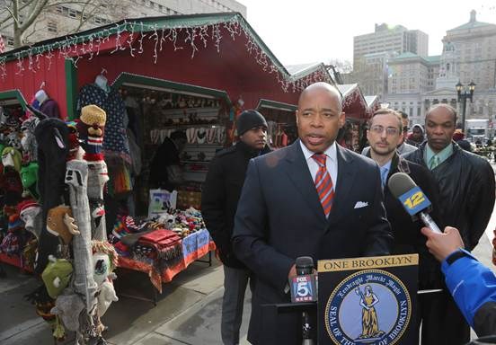 Brooklyn Borough President Eric L. Adams, joined by Brian McLaughlin, interim executive director of the Congress of Racial Equity (CORE) (2nd from right), launched the inaugural Holiday Market Village in Columbus Park.                                   Photo: Kathryn Kirk/Brooklyn BP's Office