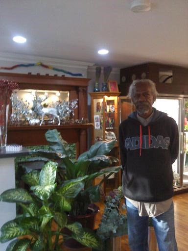 Harold King in his shop Flowergarden next to some of his beautiful houseplants.