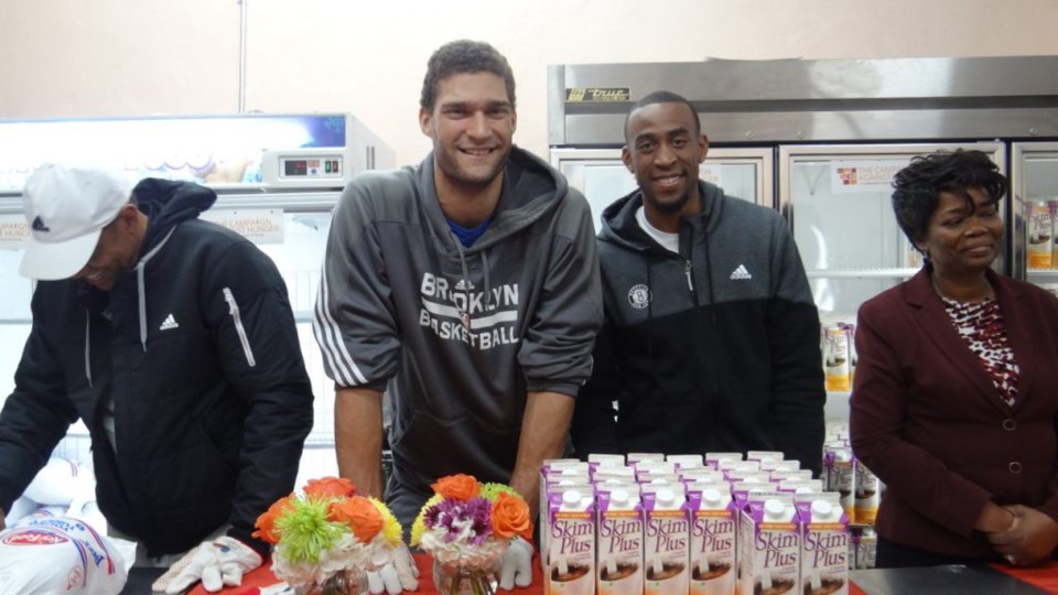 (l to r) Brooklyn Nets players Brook Lopez and Markel Brown work alongside Dr. Melony Samuels, executive director of The Bed Stuy Campaign Against Hunger