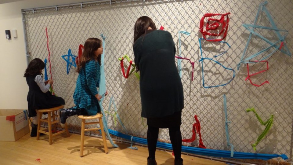Oasa Duverney and Mildred Beltre of Brooklyn Hi-Art Machine's iconic fence weaving project offers visitors an opportunity to author and illustrate a message that they want to share with their neighbors.