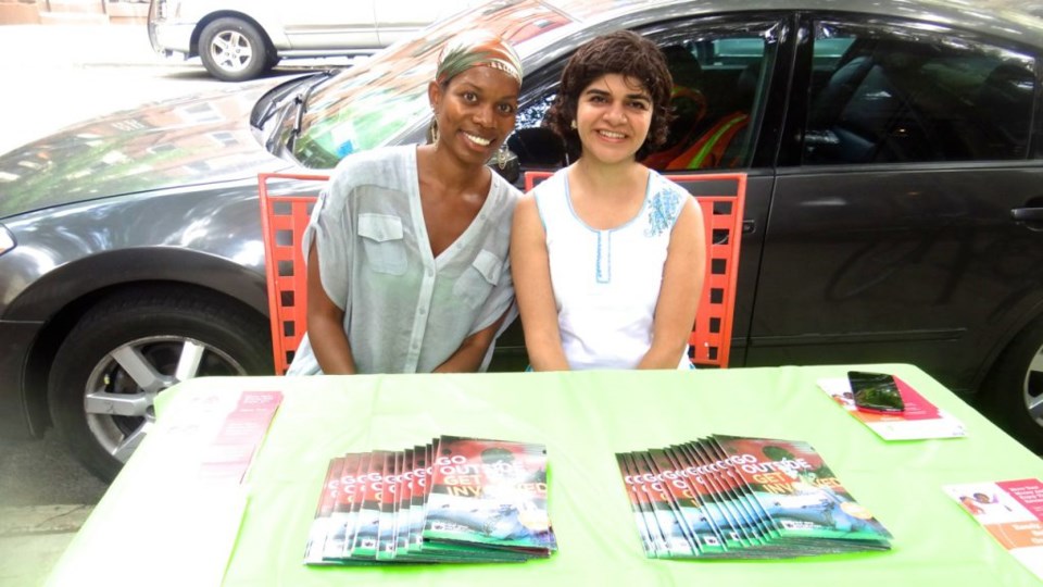 Trina Morris, founder of Style Root PR and Samira Rajan, CEO of Brookyn Cooperative Federal Credit Union talk to local residents outside of Garden of Hope in Bed-Stuy
