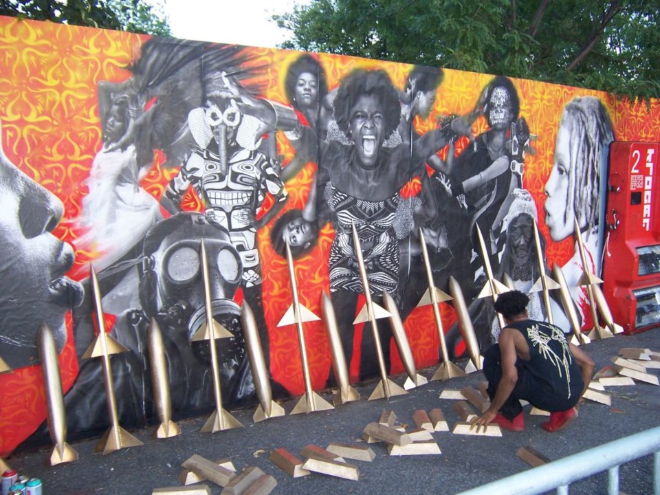 Artist Miguel Ovalle at work on his wall mural at Afropunk 2016