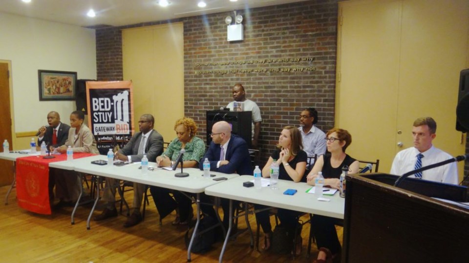 Panelist at the town hall meeting: (l to r) Henry Butler, CB3 District Manager; Tremaine Wright, CB3 Chair; Michael Lamber, Bed-Stuy Gateway BID; Marian Maura, DHS; Matthew Gordon, DHS, Claire Sheedy, Vice President of housing operations and programs, Breaking Ground; Amy Pospifil, Deputy VP, Breaking Ground; Doug Becht, VP, Breaking Ground