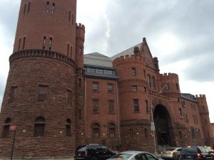 An angled view of the front of the 23rd Regiment Armory on Beford and Atlantic. The brick and stone building has a turret foregrounded on the left.