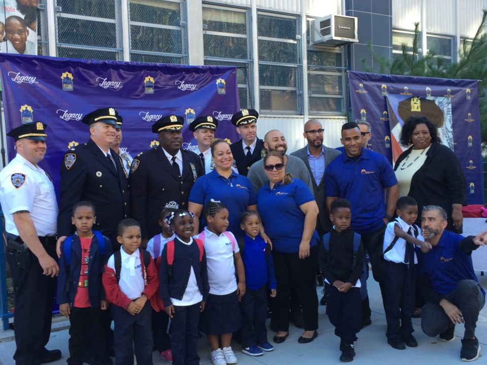 D.I. Chell, Assistant Chief Maddrey, Maritza Ramos, Jordan Durso, Pastor Ralph Castillo, and Principal Best pose with foundation members, officers from the 79th Precinct and students from P.S. 59