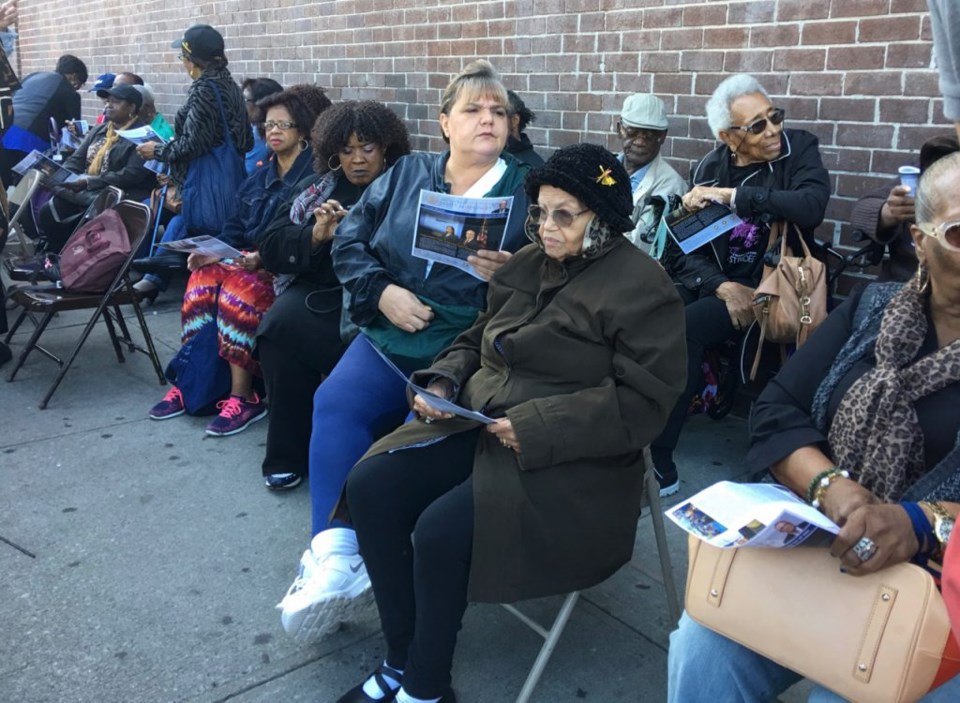 Senior members of the Fort Greene Senior Citizens Council sit outside of the senior center during the announcement