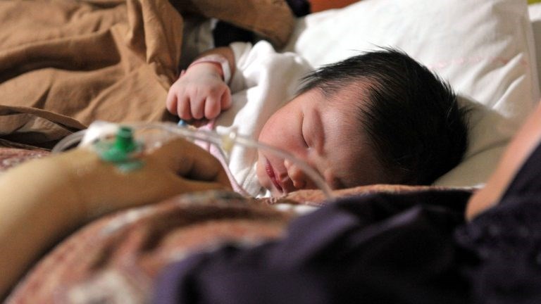 A newborn Indonesian baby girl named Malika Ifrania Altha Meara is placed next to her mother Melinda Irmayanti at the Bunda Hospital in Jakarta, where 12 lucky babies were born by C-section on December 12, 2012.  Several hospitals in Indonesia's main cities performed more Caesarians than usual with new mothers hoping a 12-12-12 birth date will bring luck to their newborns.       AFP PHOTO / BAY ISMOYO        (Photo credit should read BAY ISMOYO/AFP/Getty Images)