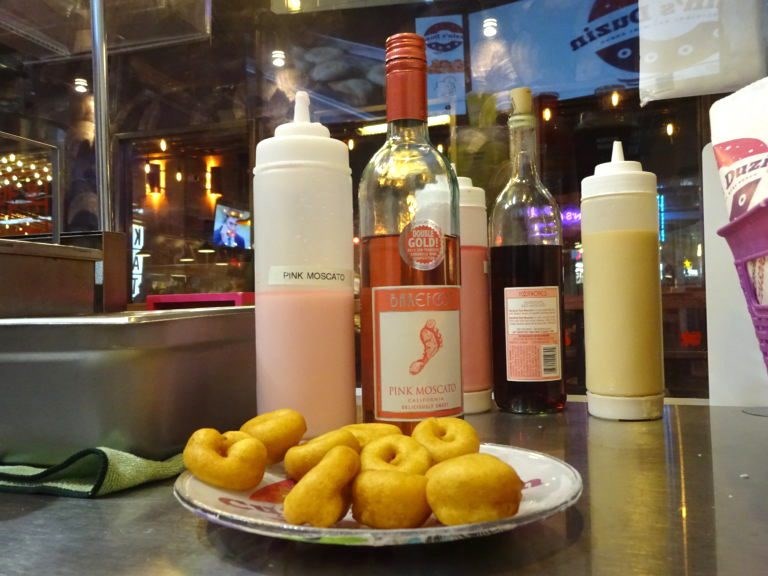 Cuzin's Duzin's pink Moscato glaze adds a fruity flavor to the fluffy donuts.